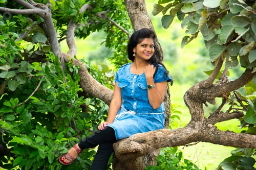 Preview: Girl sitting on a tree in forest.