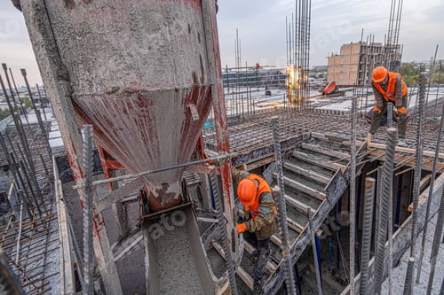Preview: High-angle shot of men working on the concrete pouring bucket in the industrial construction