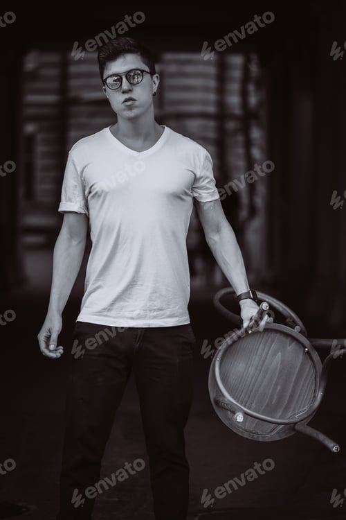 Preview: portrait of men standing with chair in white t-shirt and sunglasses in the street