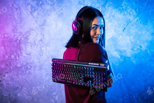 Preview: Beautiful Friendly Pro Gamer Streamer Girl Posing With a Keyboard in Her Hands, Wearing Glasses