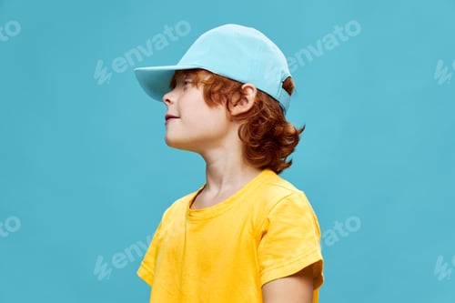 Preview: A child in a blue cap looks towards the red-haired