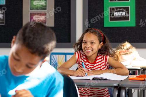 Preview: In school, diverse group of young students focusing on their work in the classroom