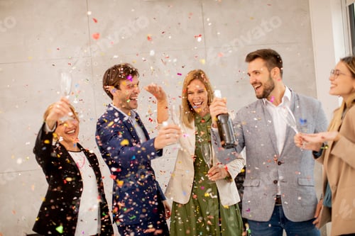 Preview: Group of business people celebrating and toasting with confetti falling in the office