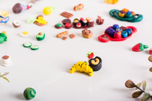 Preview: Croissant and cake and other polymer clay food on a light background. Children's leisure.