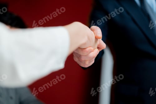 Preview: close-up in office against the background of red walls handshake between the boss and the employee