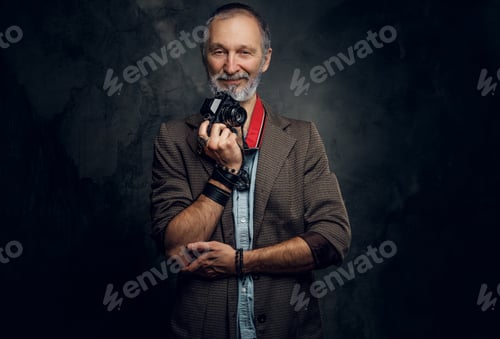 Vorschau: Älterer Mann mit Fotokamera in stilvoller Freizeitkleidung