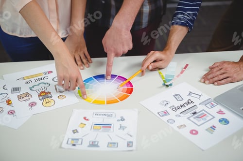 Preview: Mid section of graphic designers interacting with each other while working