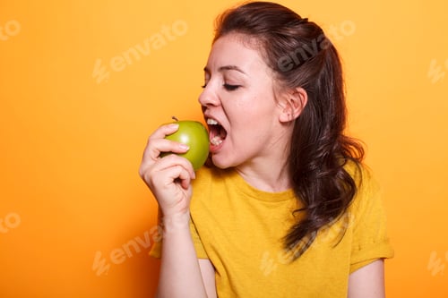 Preview: Healthy woman biting a green apple