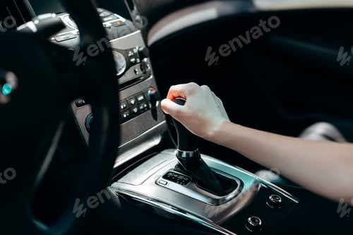 Preview: Interior of black car salon. Female hand on transmission