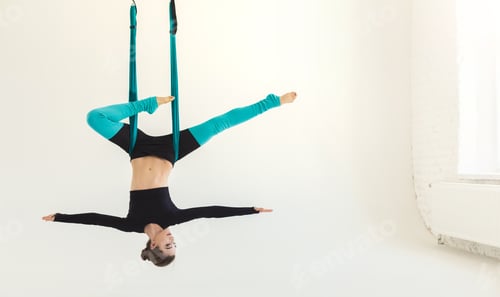 Young Woman Doing Aerial Yoga In Studio