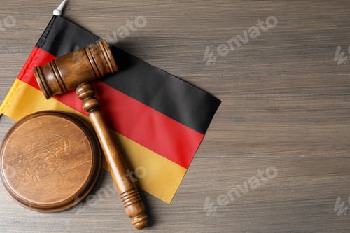 Preview: Judge's gavel and flag of Germany on wooden table, top view. Space for text