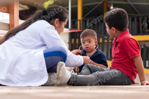 Preview: Down syndrome child surprised to hear his heart with a stethoscope. Pediatrician teaching children.