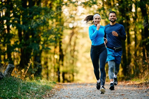 Preview: Athletic woman and her friend jogging while working out in nature.