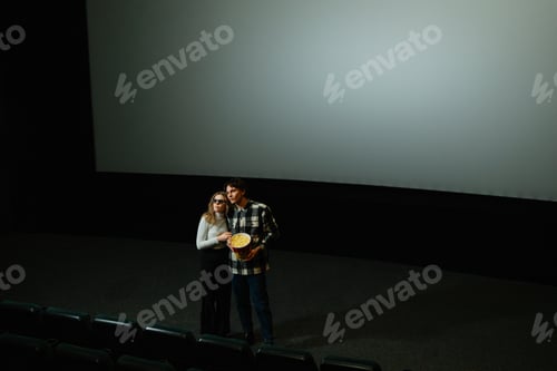 Preview: Couple enjoying a quiet moment together in an empty cinema hall