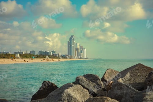 Preview: Landscape from the ocean of a beach and high rises in the distance