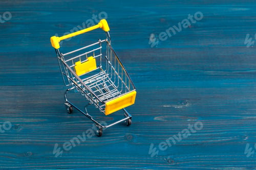 Preview: Toy shopping cart on blue wooden background