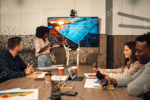 Preview: Diverse female expert with solar panel having presentation with team.