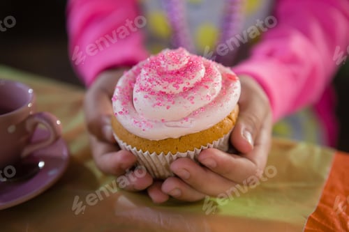 Preview: Child Holding Pink Cupcake for Birthday Celebration