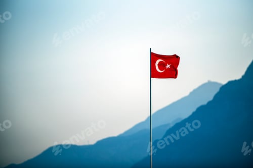 Preview: Turkish Flag waving on the wind with mountains in the background