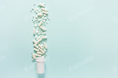 Preview: Scattered white pills on blue table.