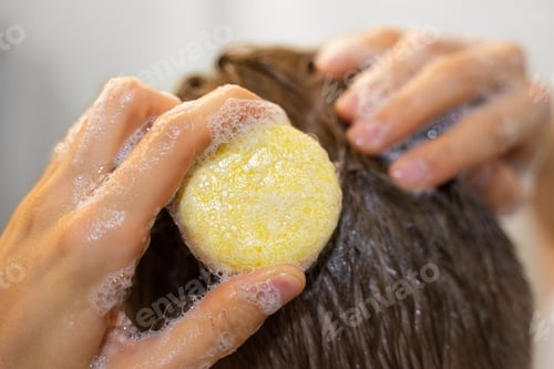 Preview: A man applies a solid shampoo bar to the hair. Man in the bathroom. Sustainable hair care