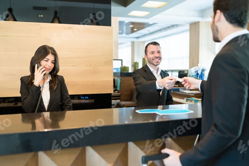 Preview: Receptionist Giving Card Key To Businessman At Lobby