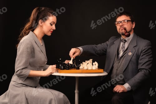 Preview: A man with a girl plays chess and smokes a pipe on a dark background