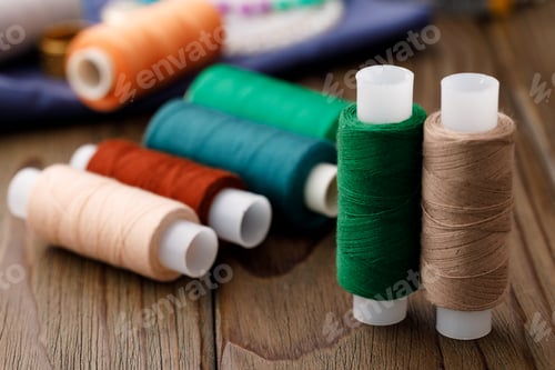 Preview: Threads and sewing accessories on brown wooden table
