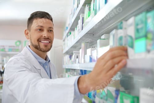 Preview: Professional pharmacist near shelves with merchandise in drugstore