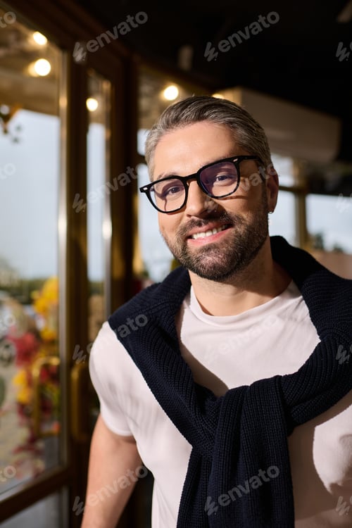 Preview: Handsome mature man in stylish outfit enjoying time at a trendy cafe