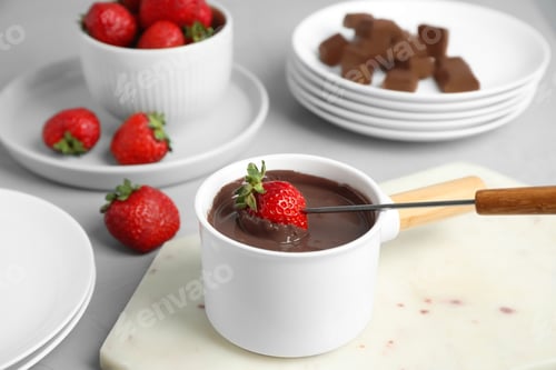 Preview: Fondue pot with chocolate and strawberry on grey table