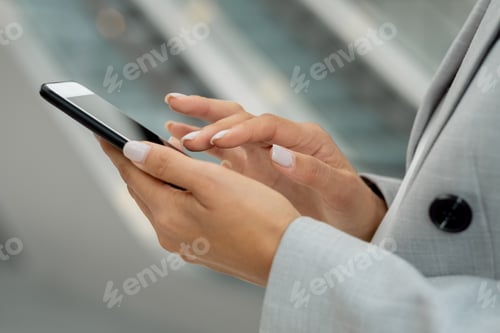 Preview: Hands of young businesswoman touching smartphone screen
