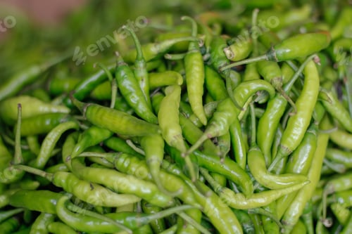 Preview: Big bucket filled with green spicy peppers in the market