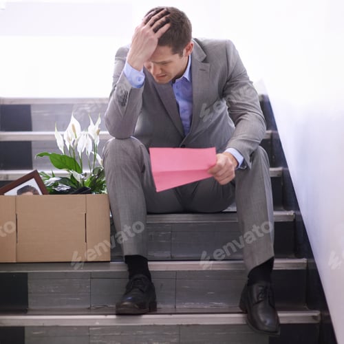Preview: Shot of a despondent businessman holding a pink slip terminating his employment