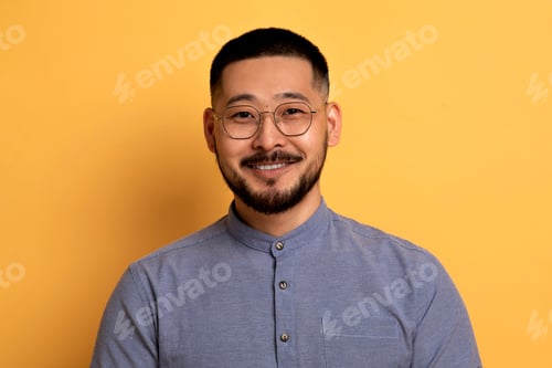 Preview: Portrait Of Handsome Young Asian Man In Eyeglasses Posing Over Yellow Background