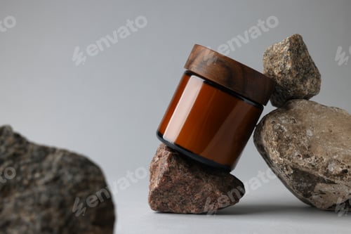 Preview: Glass jar and stones on grey background, closeup