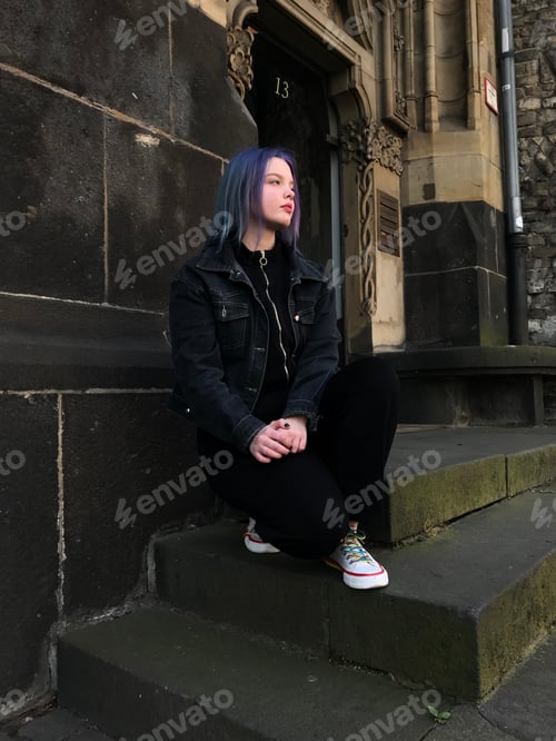 Preview: teenage girl sitting near an old building