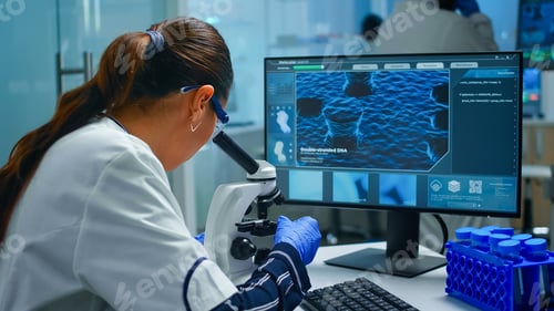 Preview: Biochemist using microscope and writing at computer working in equipped lab