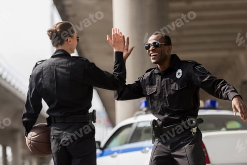 Preview: police officers with basketball ball giving high five