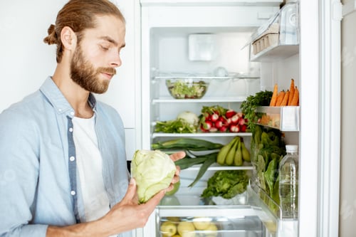 Preview: Man with fresh vegetables at the kitchen