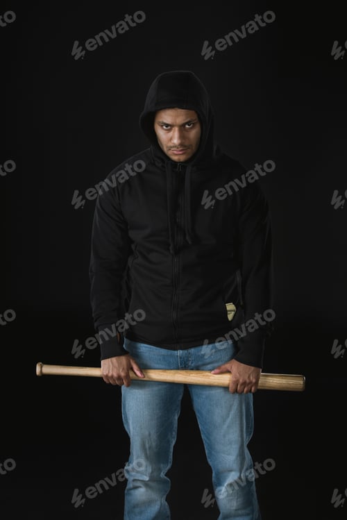 Preview: young african american robber in zoodie with baseball bat isolated on black