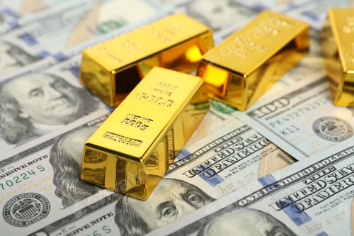Preview: Shiny gold bars on dollar banknotes, closeup