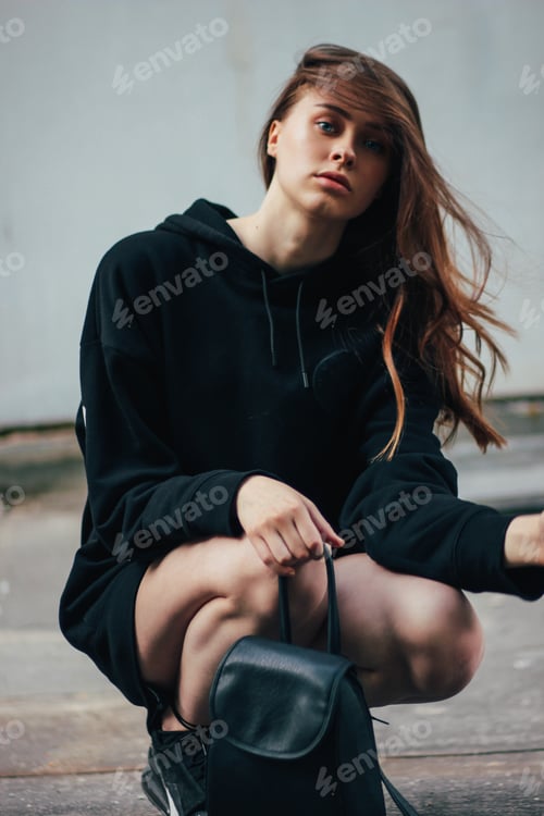 Preview: Candid portrait of young beautiful long hair girl fashion model hipster on the city street
