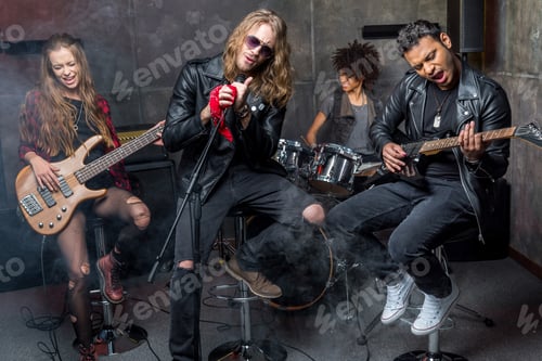 Preview: young rock band rehearsing in musical studio, band on stage concept