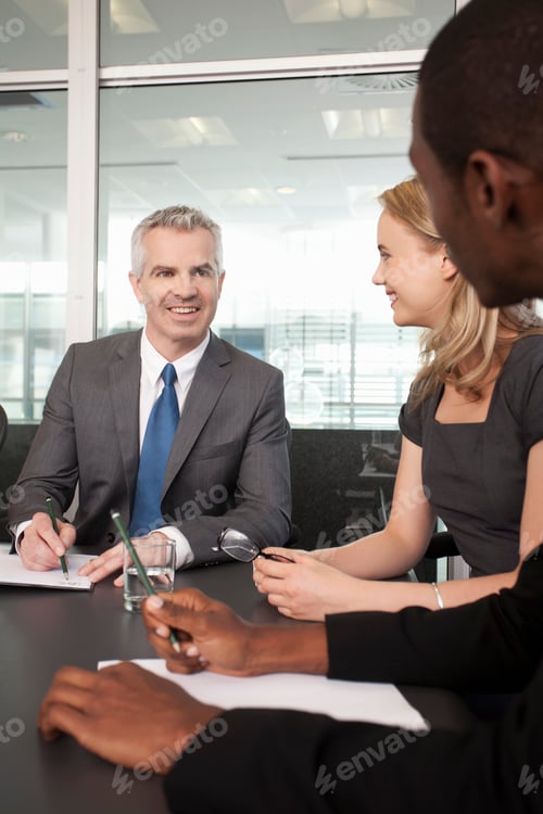 Preview: Business manager and colleagues holding meeting in office