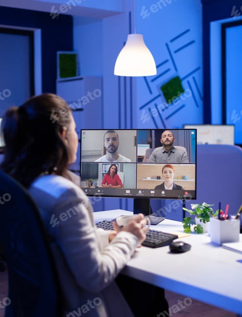 Preview: Back view of business woman talking about sale report in video conference working overtime