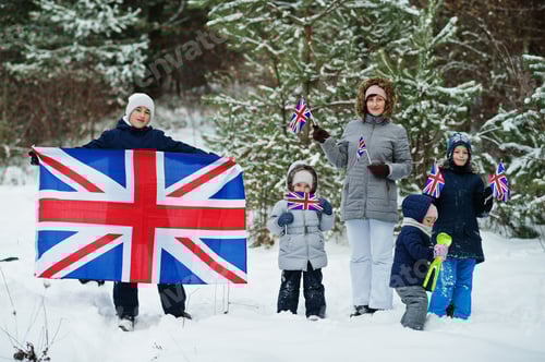 Preview: Mother with kids holding flag of Great Britain on winter landscape.