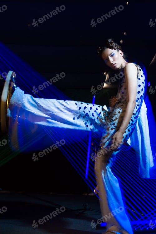 Preview: Fashion model in fashionable clothes in ultraviolet light
