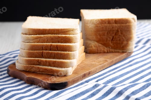 Preview: Slices of White Bread on a Rustic Wooden Board, side view.