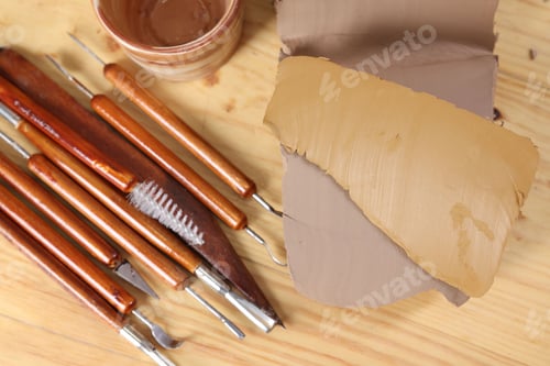 Preview: Set of different crafting tools and pieces of clay on wooden table, flat lay